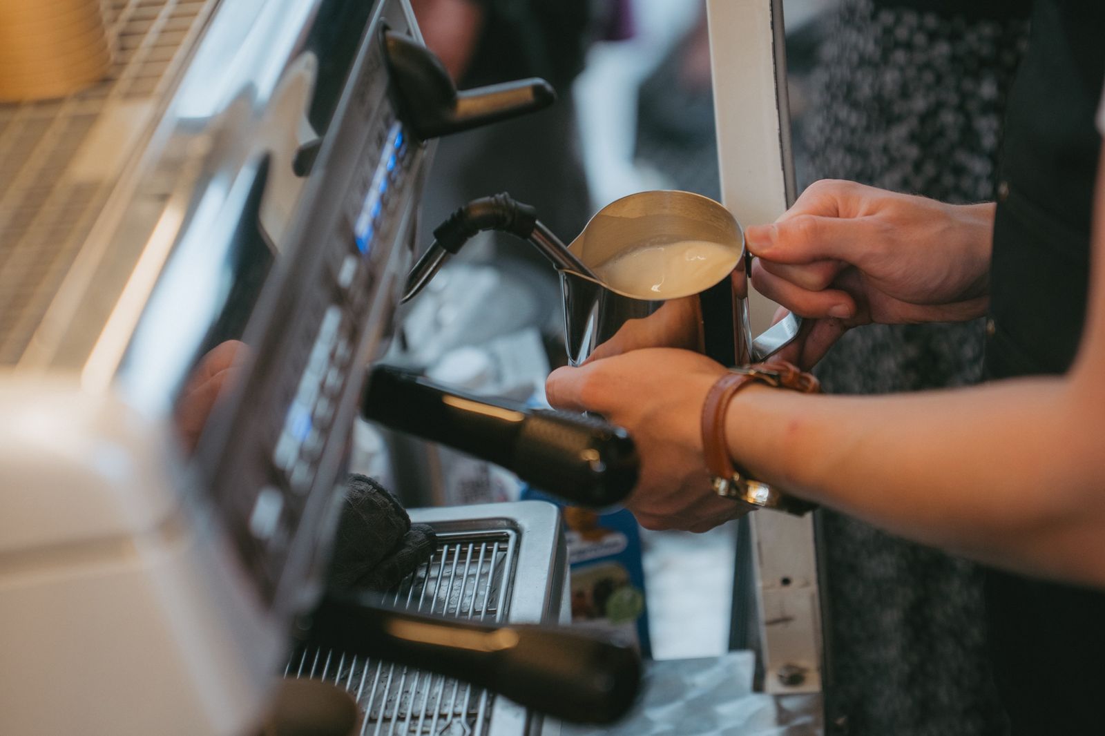 Barista schäumt Milch auf